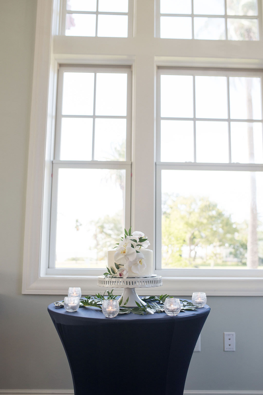 Simple, Classic Wedding Reception Decor, Round Table with Navy Blue Tablecloth, White One Tier Wedding Cake with Real White Orchid Floral | Tampa Bay Kristen Marie Photography | Planner Special Moments Event Planning