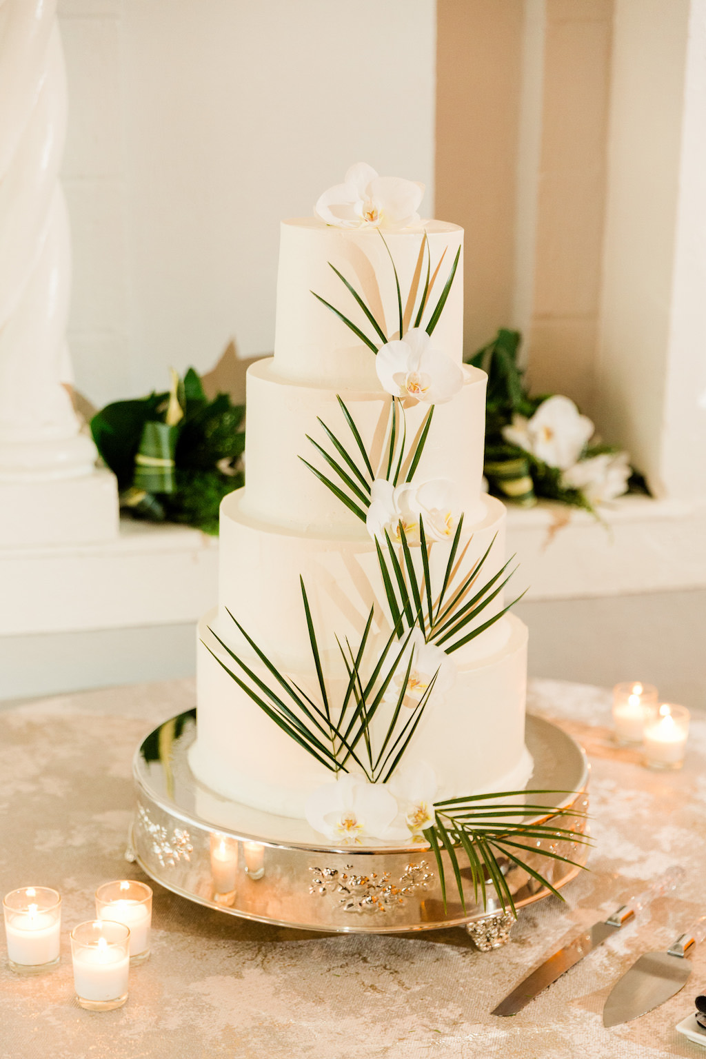 Modern, Smooth White Four Tier Wedding Cake with Dark Green Palm Leaves, White Orchid Flower, Silver Cake Stand | The Vinoy Renaissance St. Petersburg Resort & Golf Club | Luxury Florida Wedding Planner Parties A'La Carte