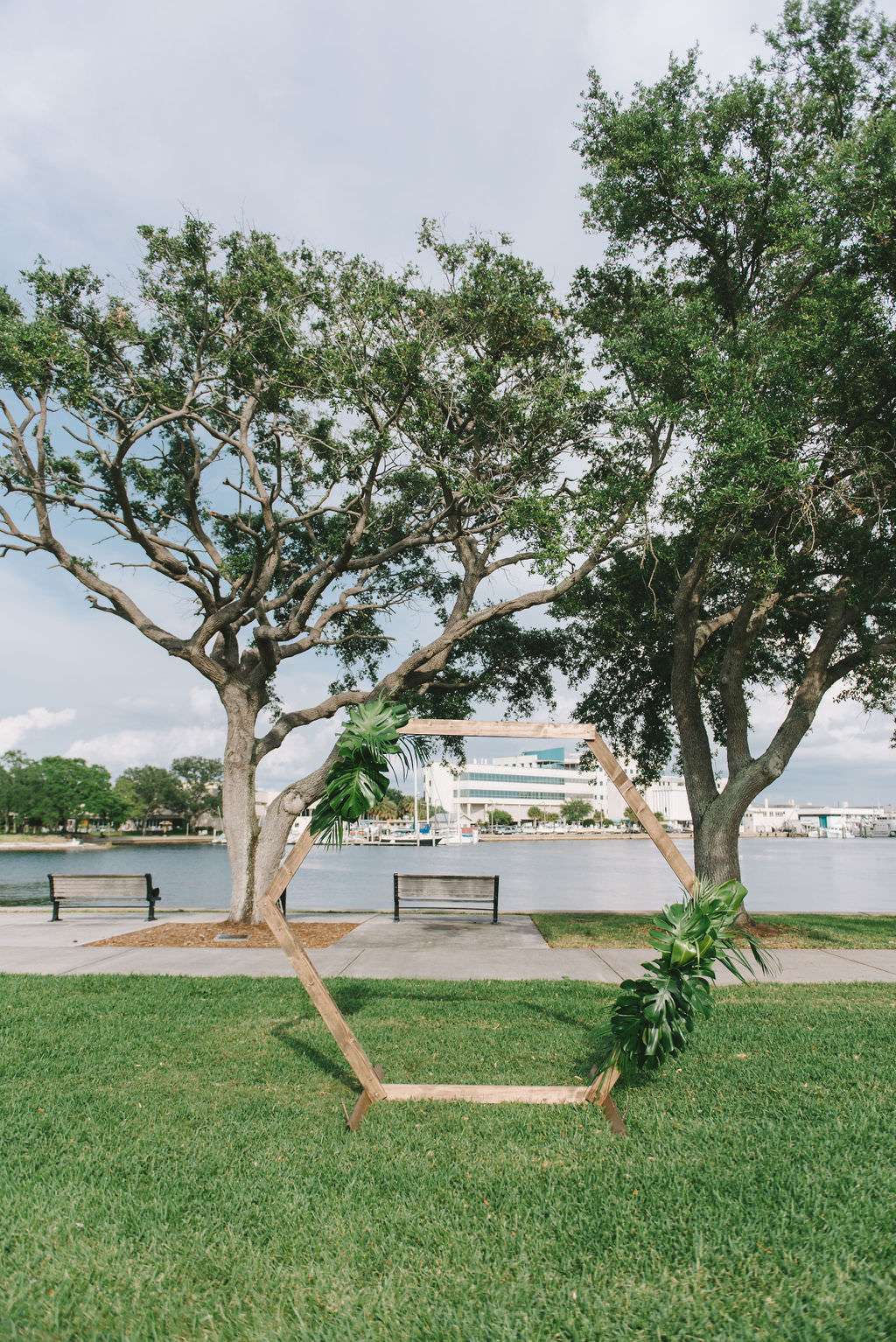 Modern, Simple Unique Outdoor Waterfront Wedding Ceremony Decor, Geometric Wooden Arch with Tropical Monstera Palm Leaves | Wedding Photographer Kera Photography | St. Petersburg Wedding Venue The Poynter Institute