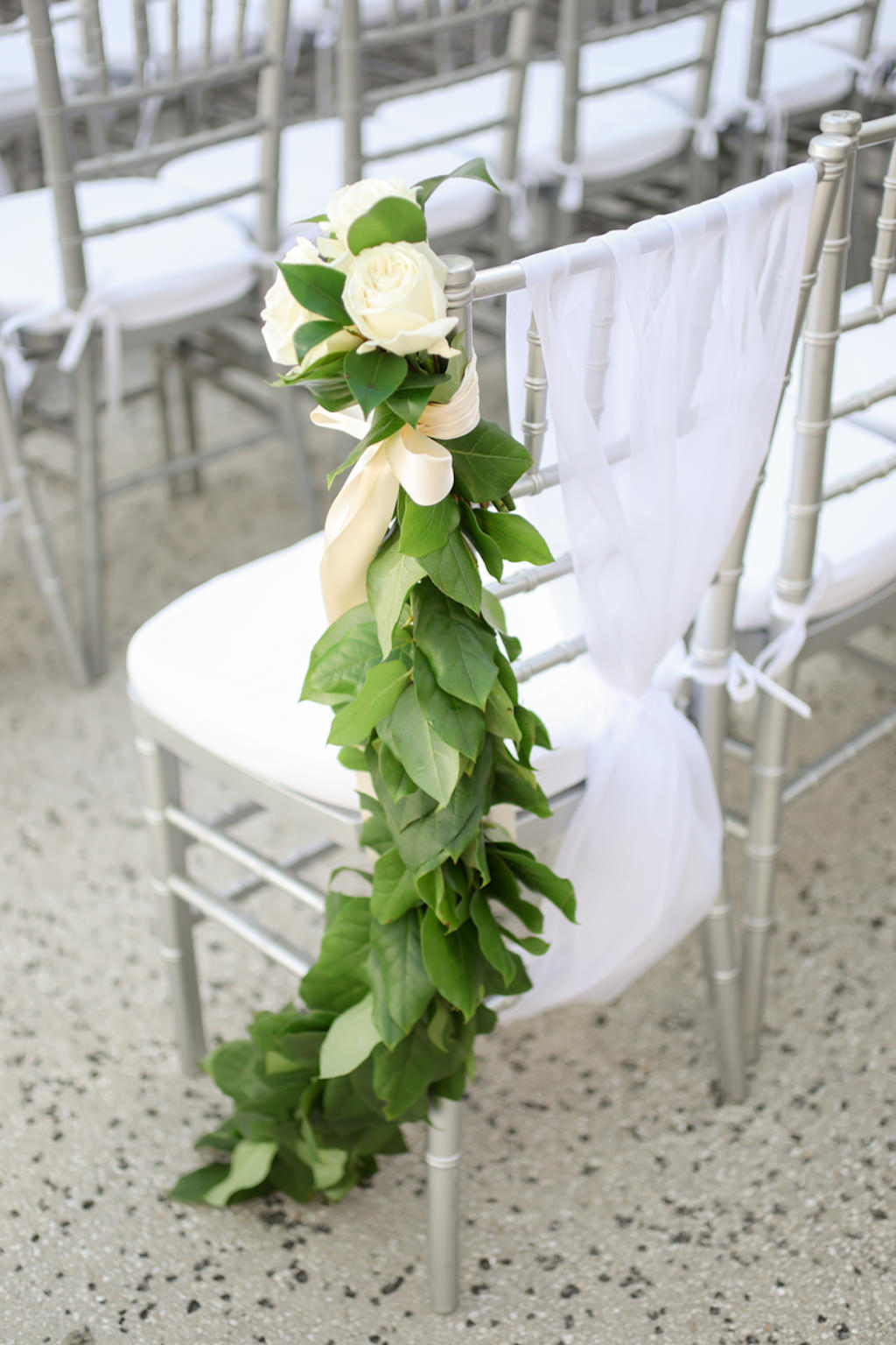 Elegant Rustic Wedding Ceremony Decor, Silver Chiavari Chairs with White Sash and Greenery Leaf Garland and Ivory Roses | Wedding Photographer Lifelong Photography Studios | Wedding Planner Kelly Kennedy Weddings and Events