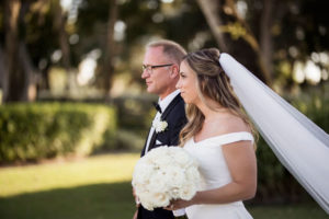 Classic, Formal Bride and Father Walking Down the Wedding Ceremony Aisle Processional in White Off the Shoulder Wedding Dress, Cathedral Length Veil and Round White, Ivory Rose Floral Bouquet
