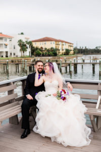 Modern, Romantic Florida Bride in Ballgown Wedding Dress, Unique Wedding Style with Purple Hair and Glasses, Holding Whimsical Bridal Bouquet, Purple, Ivory, White, Red, Flowers with Greenery | Tampa Bay Waterfront Wedding Venue Beso Del Sol