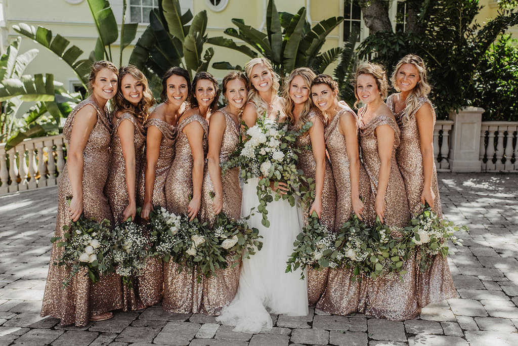 Outdoor Bride and Bridesmaids Courtyard Wedding Photo, Bridesmaids in Matching Gold Glitter Sequin Sparkly Scoop Neck Dresses, Bride in Spaghetti Strap Lace Bodice and Tulle Skirt with Organic Greenery and White Ivory Floral Bouquets Wedding Dress | Tampa Bay Wedding Hair and Makeup Femme Akoi