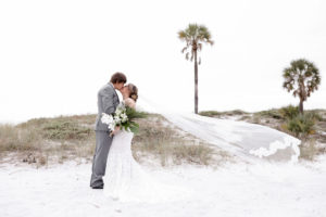 Clearwater Beach Bride and Groom Kissing with Cathedral Length Veil Blowing in Wind Creative Photo | Tampa Bay Wedding Photographer Lifelong Photography Studios