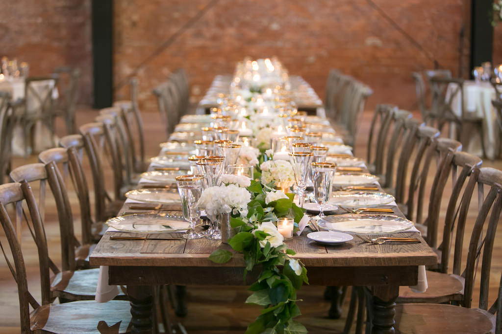 Rustic Modern Elegant Wedding Reception Decor, Long Wooden Feasting Table with Greenery Garland, Wooden Crossback Chairs and White Floral Arrangements | Tampa Bay Wedding Photographer Carrie Wildes Photography | Industrial Tampa Wedding Venue Armature Works | Tampa Wedding and Event Rentals by Kate Ryan Event Rentals