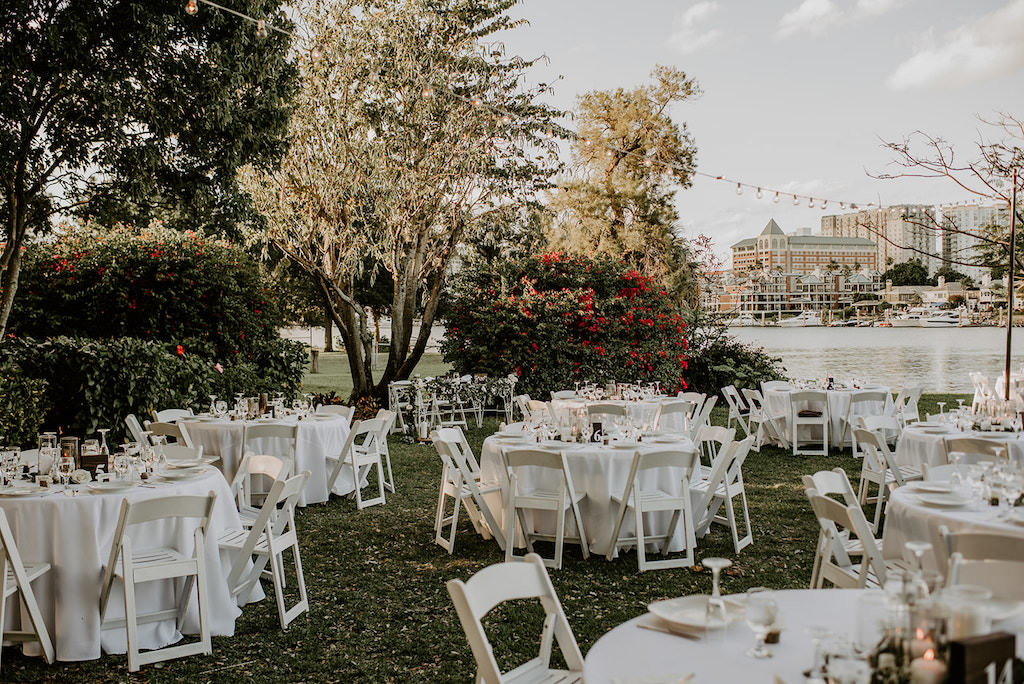 Classic, Natural, Organic Waterfront Wedding Garden Reception Decor, Round Tables wit White Linens, White Folding Chairs and String Light | Waterfront Tampa Wedding Venue Davis Islands Garden Club | Tampa Bay Wedding Rentals and Catering by Elite Events Catering