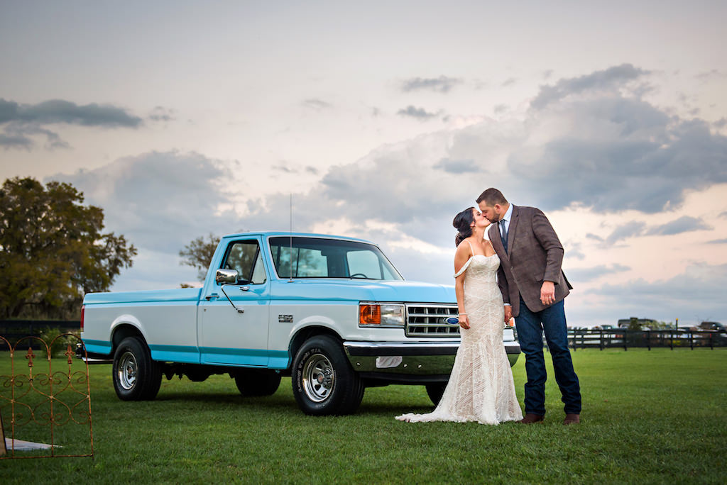 Intimate Unique Kissing Bride and Groom Wedding Portrait Outside Blue Ford Truck | Tampa Bay Rustic Wedding Venue Covington Farms