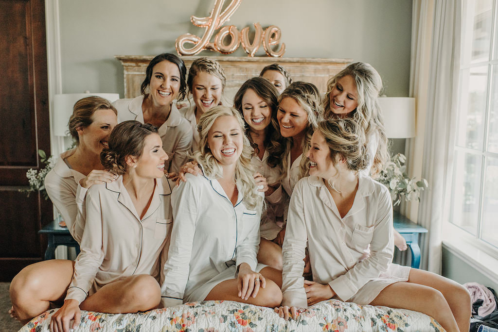 Florida Bride and Bridesmaids Getting Ready in Matching Nude Long Sleeve Pajamas and Rose Gold Love Balloon Decor in Hotel Suite | Tampa Bay Hair and Makeup Artist Femme Akoi