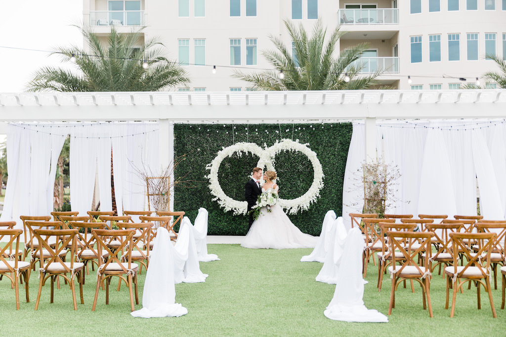 Modern, Elegant Florida Bride and Groom, At Garden Inspired Outdoor Wedding Ceremony, Gazebo Alter, Luxurious Infinity Ring Hanging Floral Arrangement with White Orchids, Dark Green Boxwood Wall, Wood Cross Back Chairs, Draping | Tampa Bay Wedding Planner Special Moments Event Planning | Tampa Bay Wedding Florist Gabro Event Services