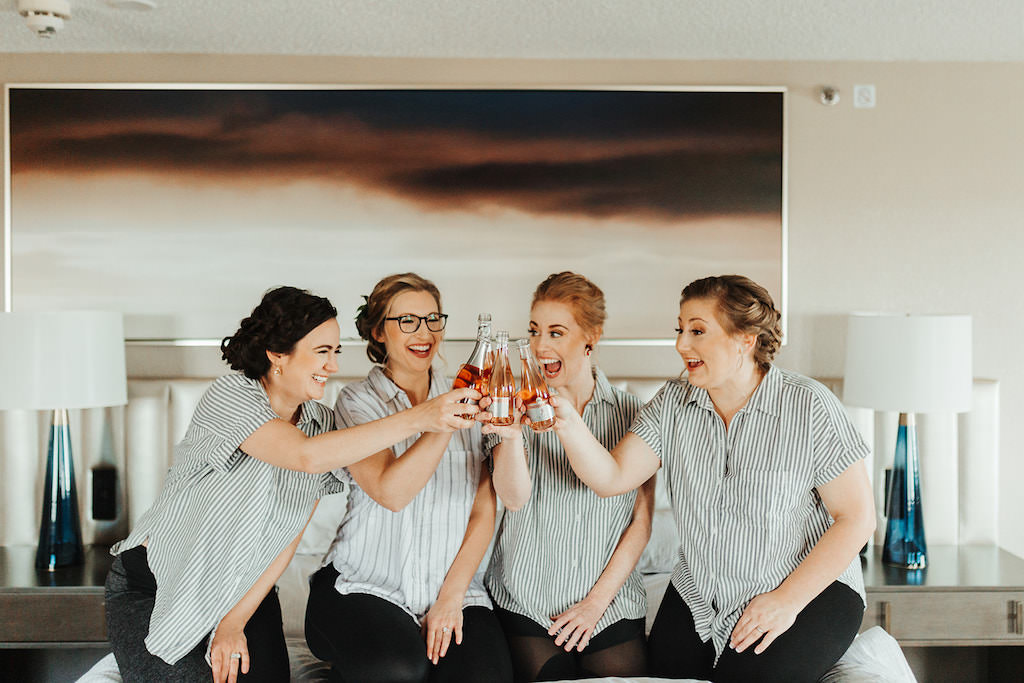Florida Bride and Bridesmaids Getting Ready Wedding Portrait in Matching Striped Pajama Shirts Cheering with Bottles of Rose
