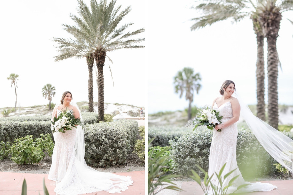 Clearwater Beach Bride Wedding Portrait in Fit and Flare Lace Spaghetti Strap V Neckline Wedding Dress with Long Cathedral Length Veil Holding Tropical Leaf and White Floral Bouquet | Tampa Bay Wedding Photographer Lifelong Photography Studios