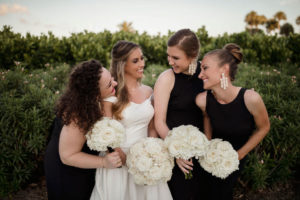 Classic, Formal Bride and Bridesmaids Wedding Portrait, Bridesmaids in Black Dresses and Bride in Calla Blanche Off the Shoulder White Wedding Dress Holding Traditional Round White, Ivory Rose Floral Bouquets | Tampa Bay Wedding Hair and Makeup LDM Beauty Group