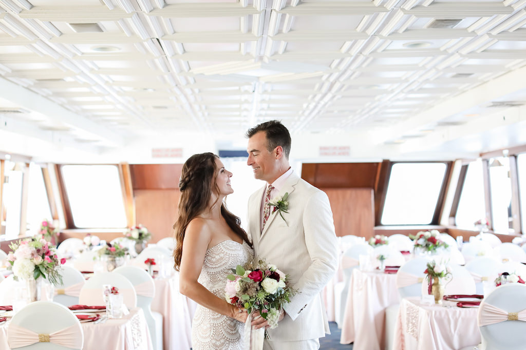 Classic Bride and Groom Wedding Portrait, Bride in Strapless Sweetheart Neckline Lace Wedding Dress Holding White, Pink, Burgundy and Greenery Floral Bridal Bouquet, Groom in White Suit | Tampa Bay Wedding Photographer Lifelong Photography Studio | Clearwater Waterfront Wedding Venue Yacht Starship | Tampa Bay Wedding and Event Rentals by Kate Ryan Event Rentals