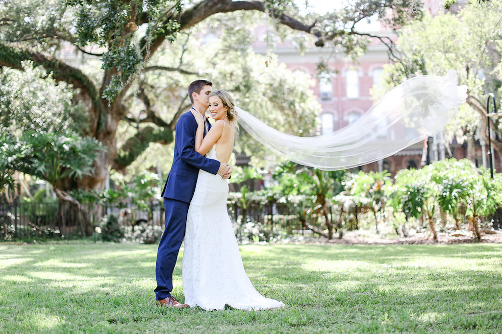 Classic Romantic Bride and Groom Outdoor Creative Wedding Portrait with Veil Blowing in Wind | Tampa Bay Wedding Photographer Lifelong Photography Studio