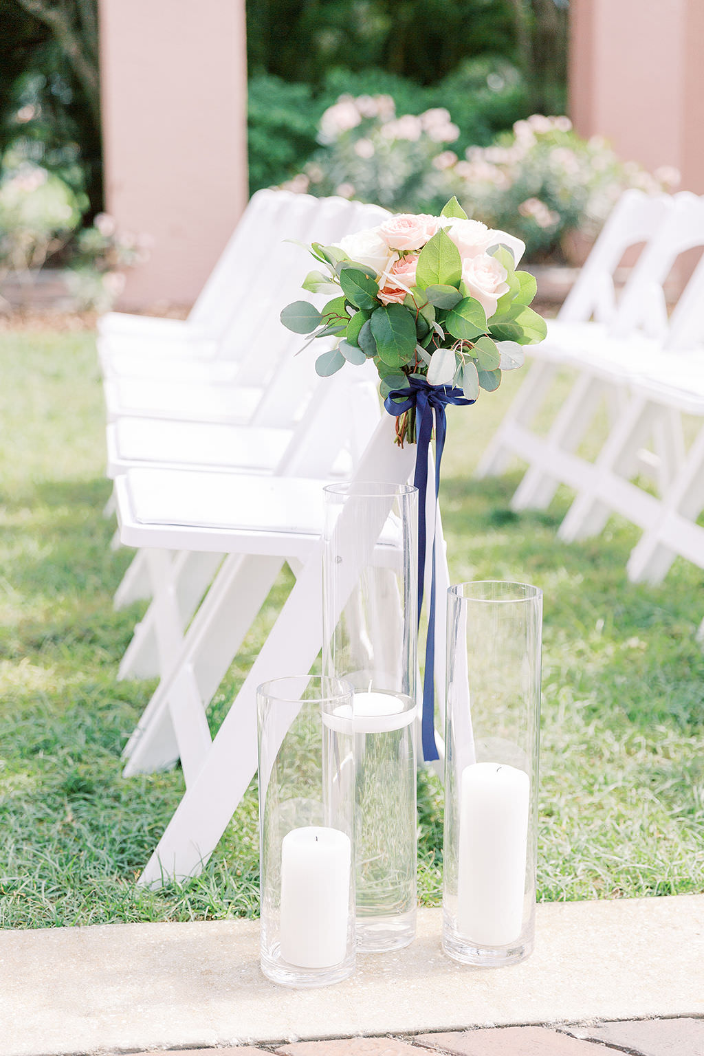 Tampa Bay Elegant Classic Wedding Ceremony Decor, White Folding Chairs with Eucalyptus Greenery, Blush Pink and Ivory Floral Arrangements, Tall Glass Hurricane Vases with Candles