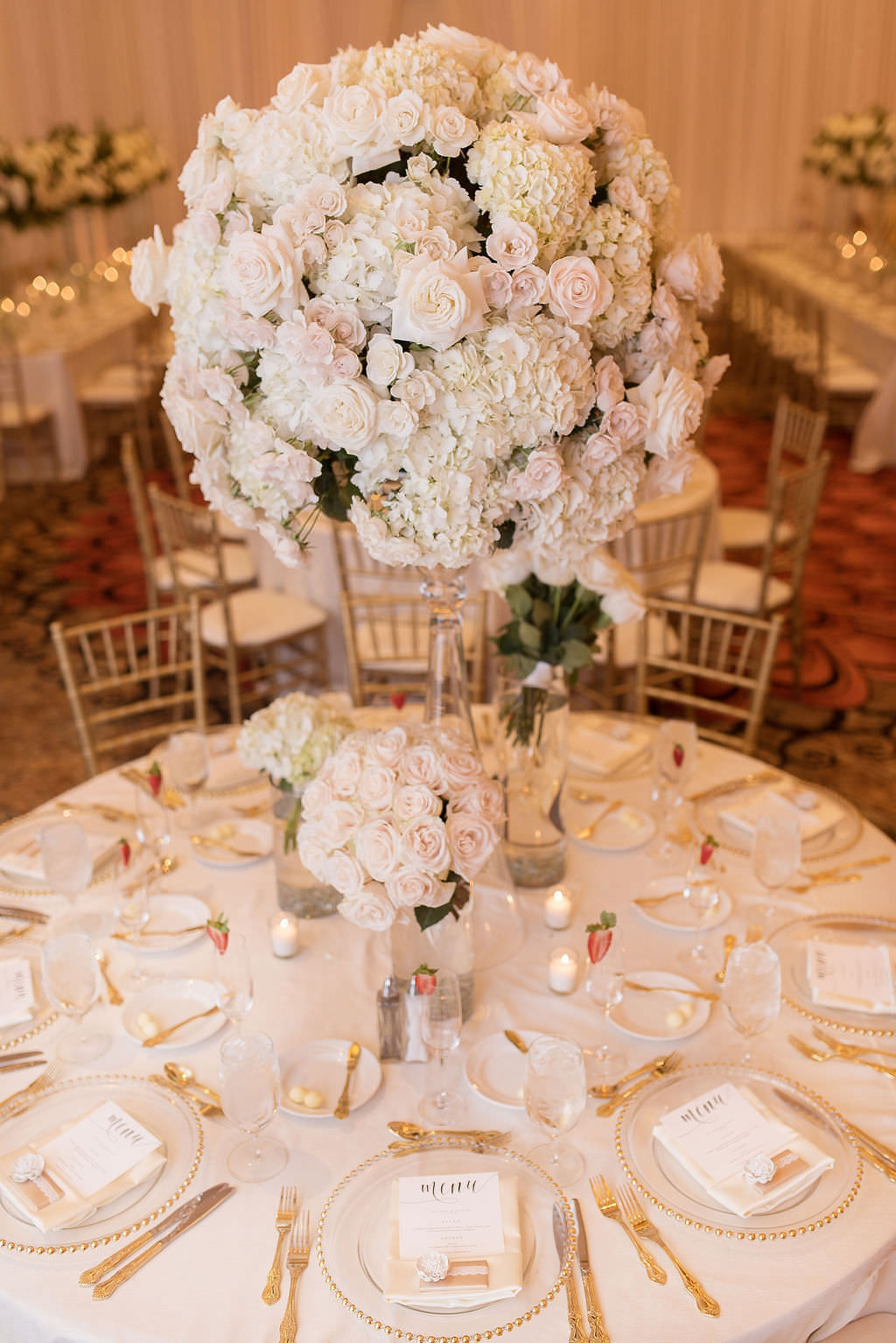 Elegant Romantic Classic Wedding Reception Decor, Lush White, Ivory and Blush Pink Floral Centerpiece on Clear Glass Vase, Round Table with White Linen, Clear Glass and Gold Beaded Rim Chargers and Gold Silverware | Tampa Bay Wedding Photographer Kristen Marie Photography | Clearwater Beach Wedding Florist, Rentals, Linens Gabro Event Services | Wedding Day of Coordinator Special Moments Event Planning