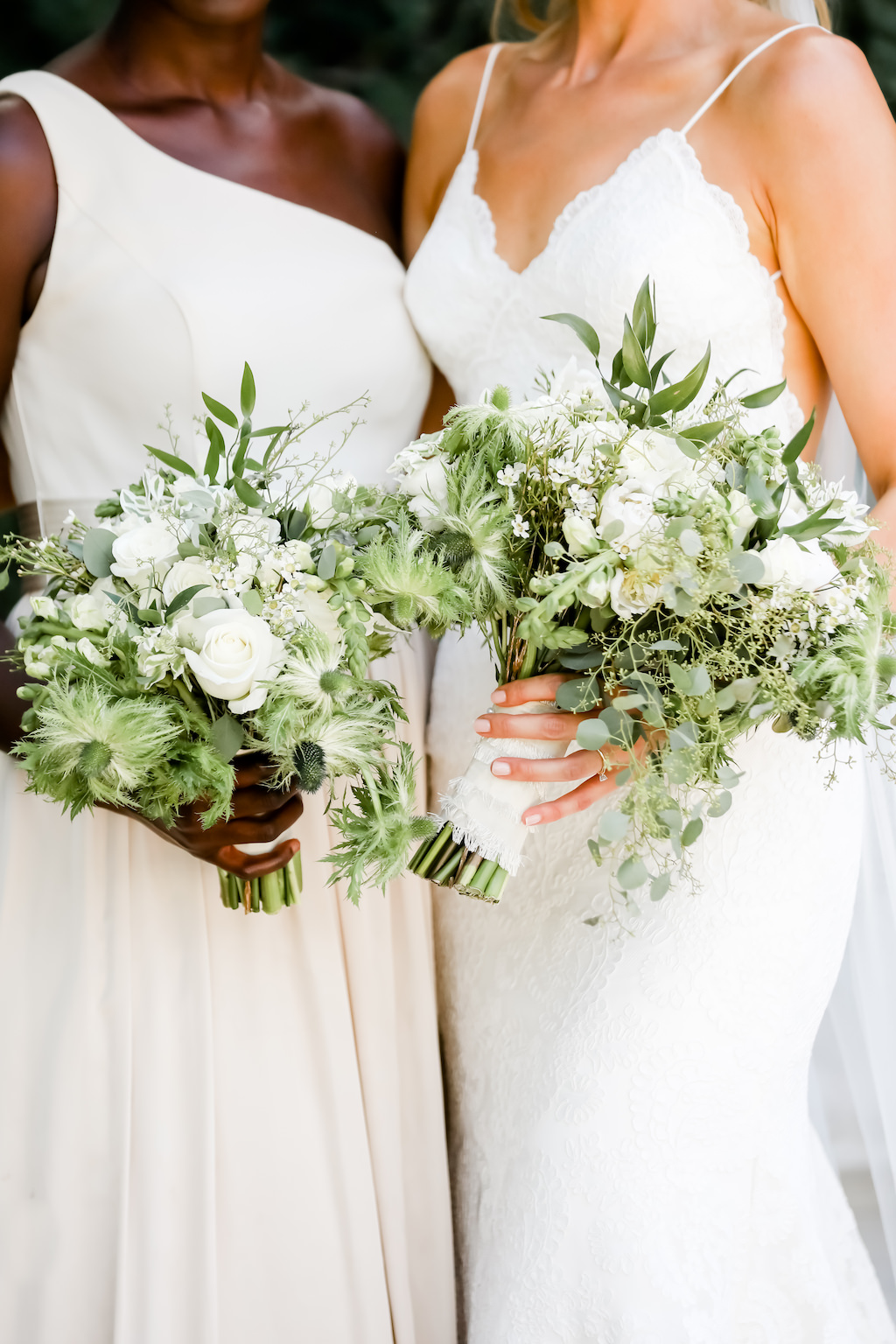 Florida Bride and Bridesmaid in Neutral One Shoulder Dress Holding Garden Inspired Greenery and White, Ivory Floral Bouquet | Tampa Bay Wedding Photographer Lifelong Photography Studio