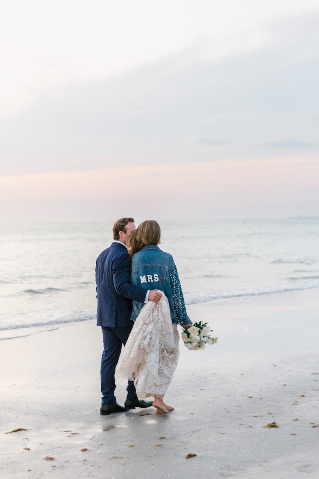 Romantic Florida Bride and Groom Walking on the Beach, Bride in Custom Mrs Jean Jacket