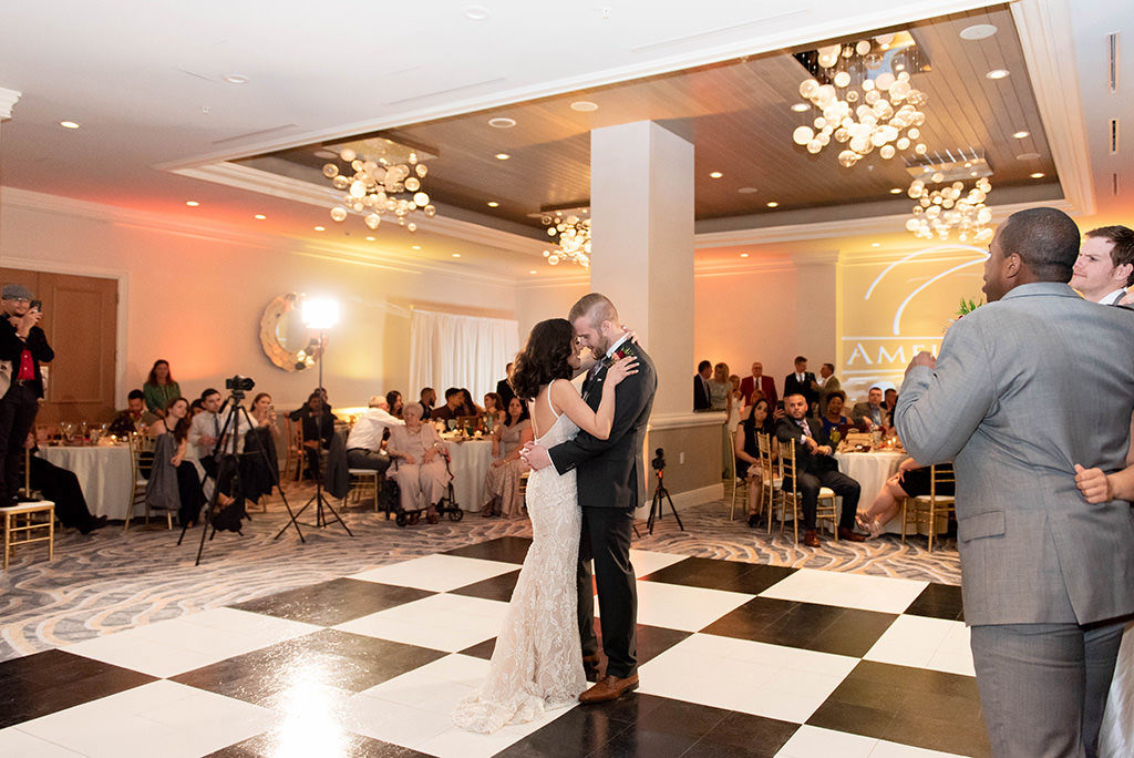 Romantic Bride and Groom First Dance Wedding Reception Portrait on Black and White Checkered Dance Floor, Modern Chandeliers | Clearwater Beach Wedding Venue Hyatt Regency Clearwater Beach | Clearwater Beach Wedding and Event Rentals by Gabro event Services