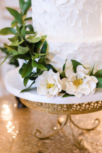 Elegant, White Two-tier textured Buttercream Wedding Cake with Edible Sugar Flower and Greenery Accents, Gold Sequined Cake Table cloth | Tampa Bay Wedding Cake Artists Alessi Bakery