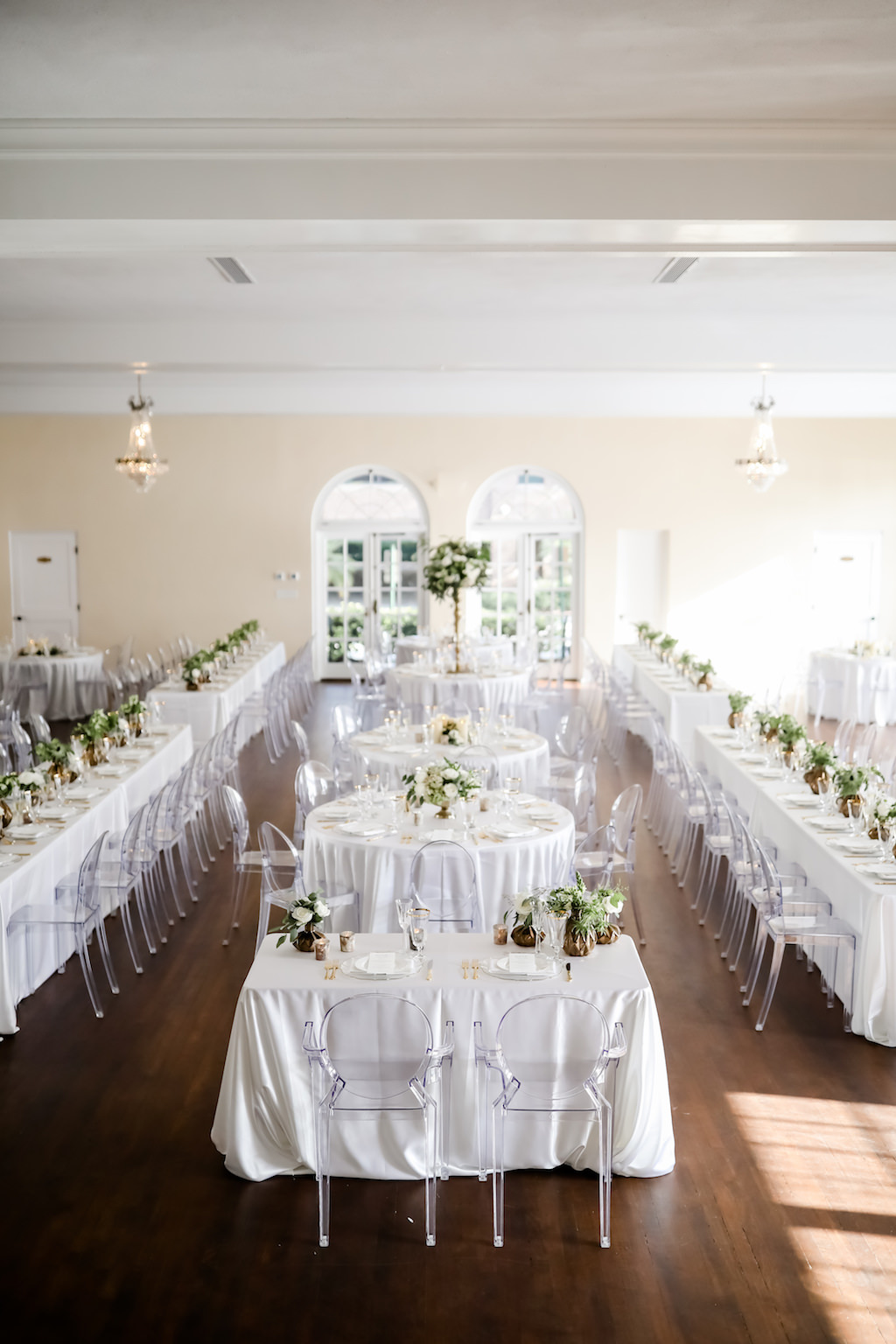Classic Neutral Wedding Reception Decor, Long Feasting Tables and Round Tables with White Linens, Low Gold Vases with Ivory and Greenery Florals, Clear Ghost Acrylic Chairs | Tampa Bay Wedding Photographer Lifelong Photography Studio | Wedding Rentals Kate Ryan Event Rentals | Historic Wedding Venue The Orlo