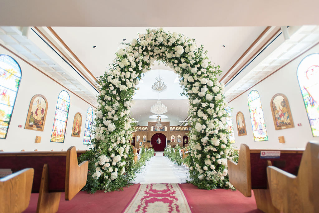 Stunning Classic Elegant White Ivory and Greenery Wedding Ceremony Floral Arch Entrance | Tampa Bay Wedding Photographer Kristen Marie Photography | Traditional Wedding Ceremony Venue St. George Coptic Orthodox Church | Clearwater Beach Wedding Florist Gabro Event Services | Wedding Day of Coordinator Special Moments Event Planning