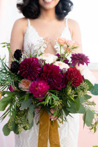 Tampa Bay Bride Holding Jewel Toned Organic Bridal Bouquet, Red, Dark Purple, Pink, Maroon, Blush Pink Floral Bouquet with Greenery and Satin Ribbons