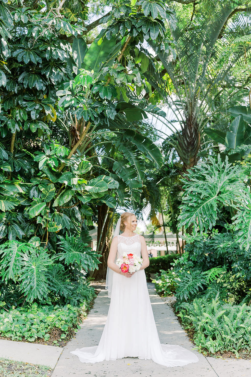 Tampa Bay Bride Wedding Portrait in Tropical Garden in High Illusion Crew Neck Neckline Wedding Dress with Colorful Pink and White Floral Bridal Bouquet