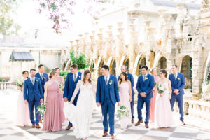 Florida Bride and Groom with Wedding Party in Outdoor Garden Courtyard, Bridesmaids in Mix and Match Pink Dresses, Groomsmen in Navy Suits | Tampa Bay Wedding Photographers Shauna and Jordon Photography