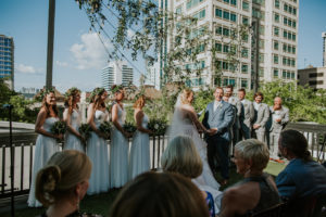 Outdoor Florida Rooftop Wedding Ceremony Bride and Groom Exchanging Vows Wedding Portrait | Downtown St. Pete Wedding Ceremony Rooftop Venue Station House