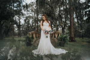 Rustic Chic Tampa Bay Bride Beauty Outdoor Wedding Portrait Wearing Lace and Illusion Fitted V Neckline Romantic Wedding Dress Holding Blush Pink and White Roses and Dusty Miller Bridal Floral Bouquet | Parrish Barn Wedding Venue Rafter J Ranch
