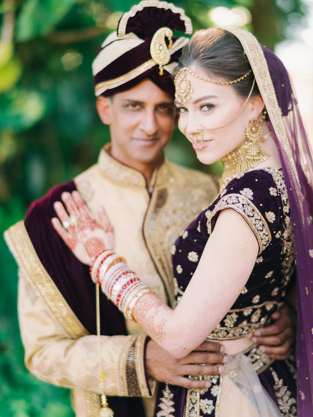 Traditional Indian Hindu Bride and Groom First Look Wedding Portrait, Groom in Black and Gold Sherwani Turban, Bride in Custom Purple Velvet and Gold Lehenga and Extravagant Gold Bridal Jewelry, Bridal Mehndi Henna Tattoo | Tampa Bay Bridal Hair and Makeup Artist Michele Renee The Studio