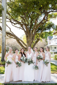 Tampa Bay Bridal Party, Bridesmaids in Mix and Match Blush Pink Dresses, Bride in Justin Alexander V Neck A-Line Wedding Dress Holding Organic Greenery and Ivory Floral Bouquets | Wedding Planner Coastal Coordinating