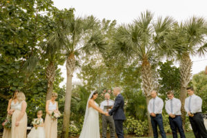 St. Pete Bride and Groom Exchanging Vows During Outdoor Garden Wedding Ceremony Portrait