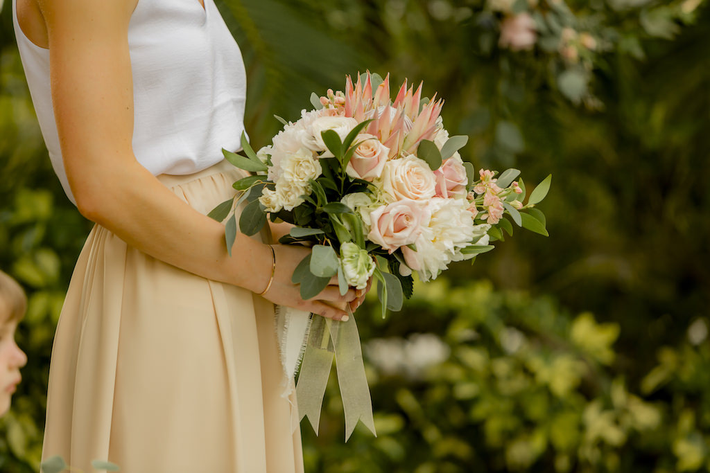 St. Pete Bridesmaid in Two Tone Color Block White and Nude Skirt Dress Holding Garden Inspired King Protea, Blush Pink and Ivory Roses, Eucalyptus Floral Bouquet