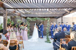 Industrial Boho Chic Wedding Ceremony Bride and Groom Exchanging Vows Wedding Portrait Under Courtyard Pergola and Greenery Adorned Arch | Tampa Bay Wedding Photographer Lifelong Photography Studio | Wedding Planner Special Moments Event Planning | Unique Wedding Ceremony Venue Fancy Free Nursery