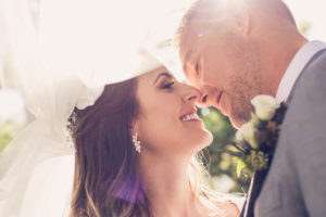 Romantic, Whimsical Creative Florida Bride and Groom Wedding Portrait with Lens Flair Under Veil | South Tampa Luxury Wedding Photographer Luxe Light Images