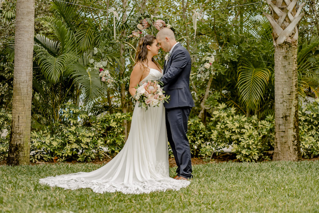 Romantic St. Pete Bride and Groom Garden Wedding Portrait, Bride in Lace Train Stella York Wedding Dress Holding King Protea, Blush Pink Roses and Greenery Floral Bouquet