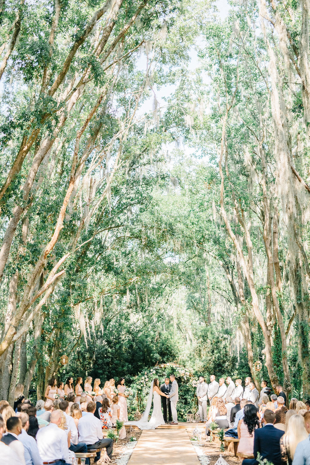 Enchanting Outdoor Wedding Ceremony Under Canopy of Oak Trees, Bride and Groom Exchanging Wedding Vows | Whimsical Tampa Bay Venue Florida Rustic Barn Weddings