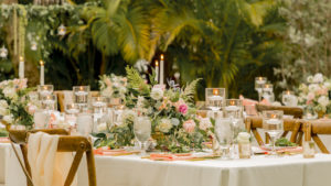 Tampa Garden Inspired Outdoor Wedding Reception Decor, Long Feating Tables, Ivory Linens, Wooden Cross Back Chair with Blush Pink Sashes and Greenery Ties, Eucalyptus, Ivory, Blush Pink Roses and Greenery Floral Centerpiece