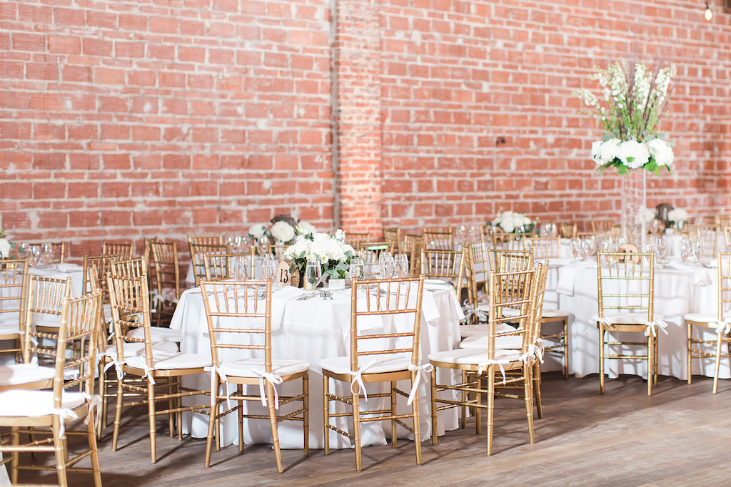 Elegant, Rustic Wedding Decor and Reception, Round Tables with Gold Chiavari Chairs, Against Exposed Red Brick Wall | Downtown St. Petersburg Historic Wedding Venue NOVA 535 | Tampa Bay Wedding Photographers Shauna and Jordon Photography