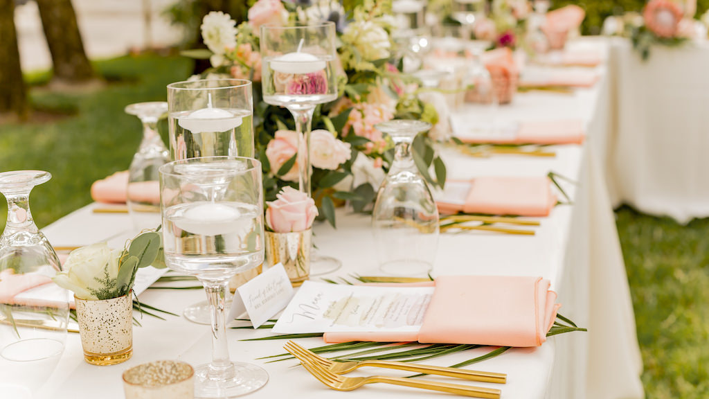 St. Pete Outdoor Garden Wedding Reception Decor, Long Feating Table, Ivory Tablecloth, Blush Pink Linen Napkins, Pink and Ivory Roses, Greenery Floral Centerpiece, Floating Candles