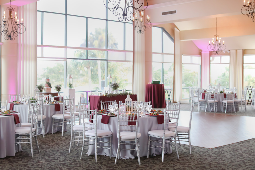 Winter Wedding Decor with Silver Chiavari Chairs, Silver Tablecloths and Maroon Napkins | Elegant Golf Course Ballroom Wedding Reception Venue with Floor to Ceiling Windows at The Bayou Club | Tampa Wedding Photographer Lifelong Photography Studio