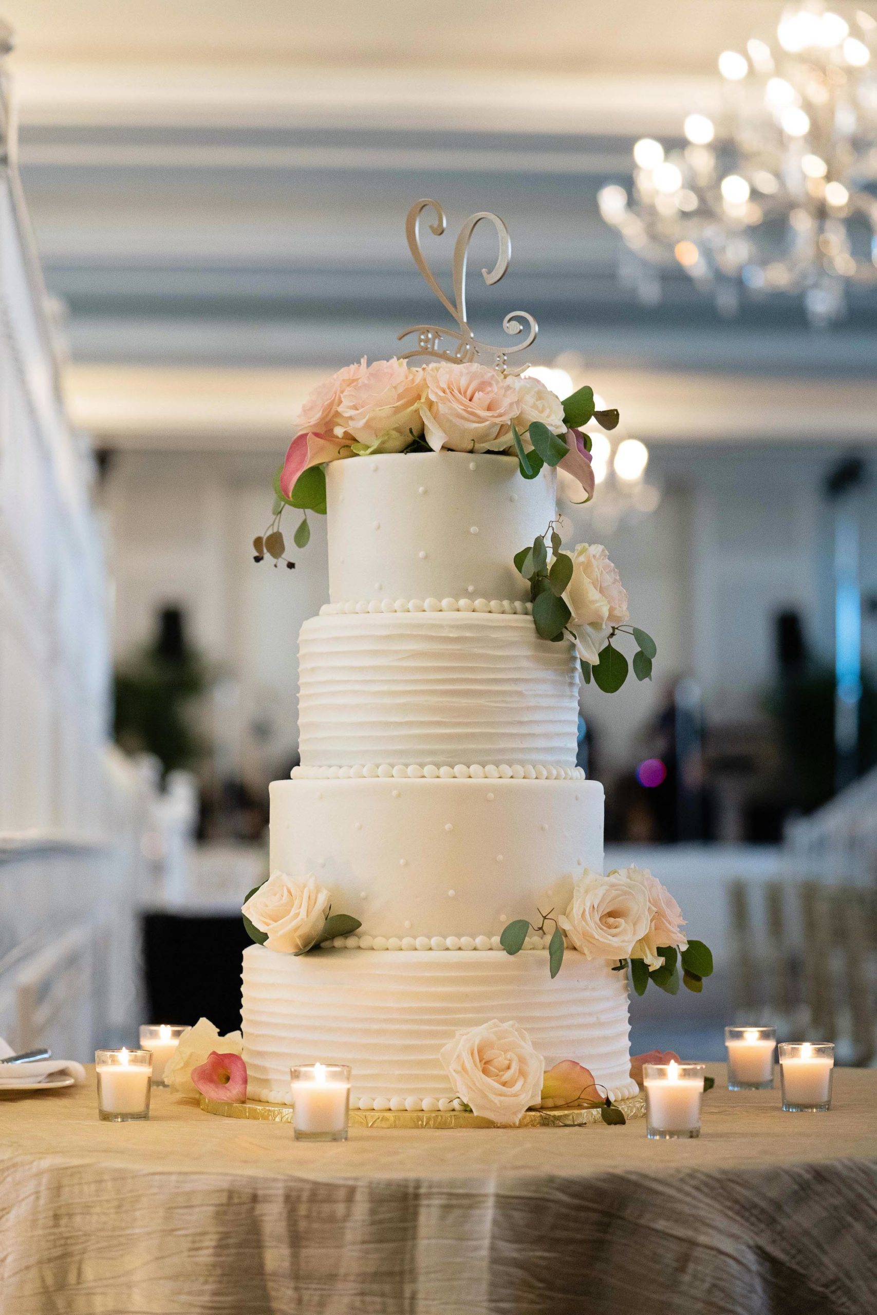 Romantic All White Four Tier Wedding Cake with Custom Monogram Silver Cake Topper and Blush Pink and Ivory Rose Floral Accents, Multi Textured Buttercream Cake by The Don CeSar Catering | Historic Tampa Bay Wedding Venue The Don CeSar in St. Pete Beach