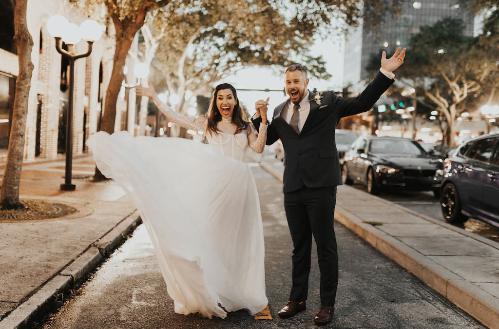 INSTAGRAM Downtown St. Pete Bride and Groom Excited Wedding Portrait | Bride in Vera Wang Lace Wedding Dress with Groom in Navy Suit