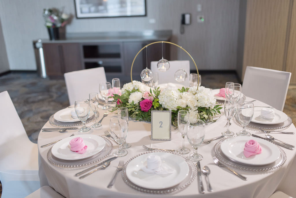 Elegant Wedding Ballroom Reception Decor, Round Table with Gray Table Linen and Chair Covers, Silver Beaded Chargers, Pink and White Linen Napkins, Round Gold with Clear Glass Hanging Globe Candles, White Hydrangeas and Pink Roses with Greenery Floral Centerpiece | Tampa Bay Wedding Photographer Kristen Marie Photography | St. Pete Wedding Florist Brides N Blooms | Outside the Box Event Rentals