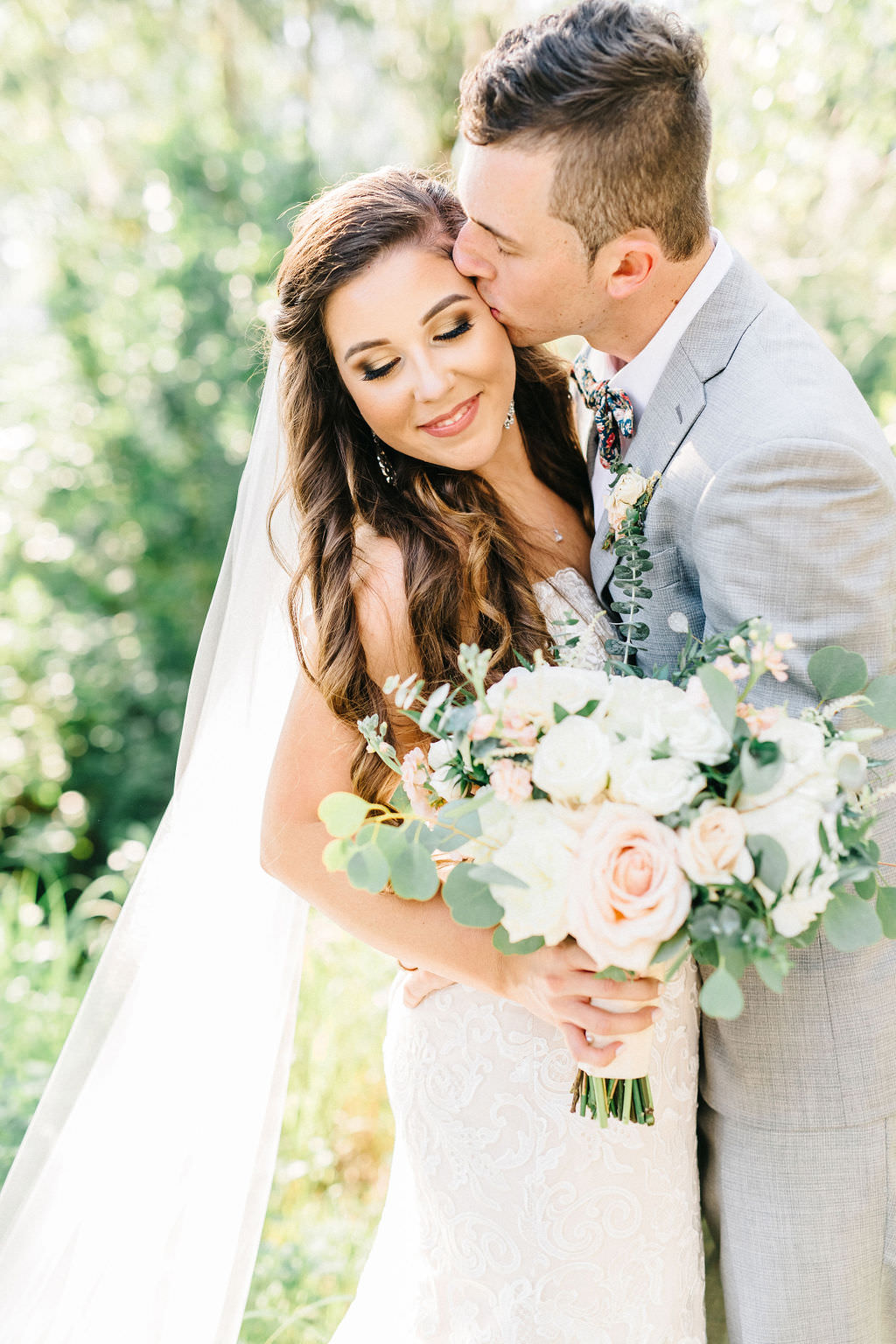 Romantic Tampa Bay Bride and Groom Wedding Portrait, Soft Bridal Bouquet with Blush Pink Roses, Ivory Flowers, White, Florals, Greenery, Groom in Light Gray INDOCHINO Suit