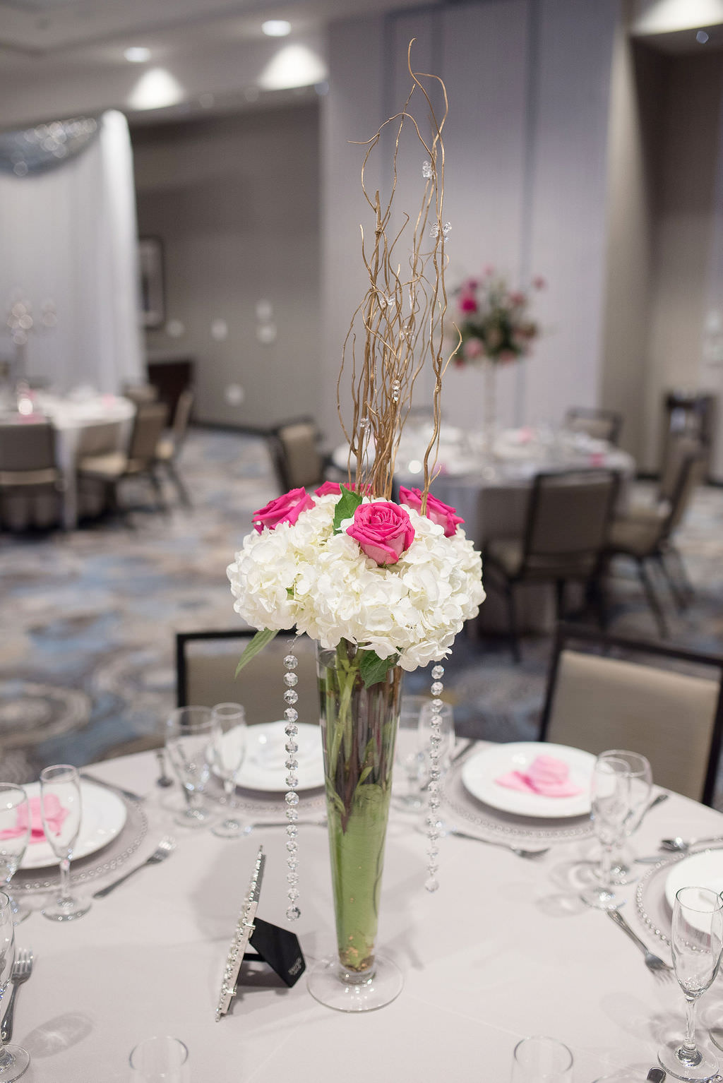Modern Elegant Wedding Reception Decor, Tall Vase with White Hydrangeas, Fuschia Pink Roses, Decorative Sticks and Hanging Crystals Floral Centerpiece | Tampa Bay Wedding Photographer Kristen Marie Photography | Hotel Wedding Venue Hyatt Place Downtown St. Pete | Wedding Florist Brides N Blooms | Outside the Box Event Rentals