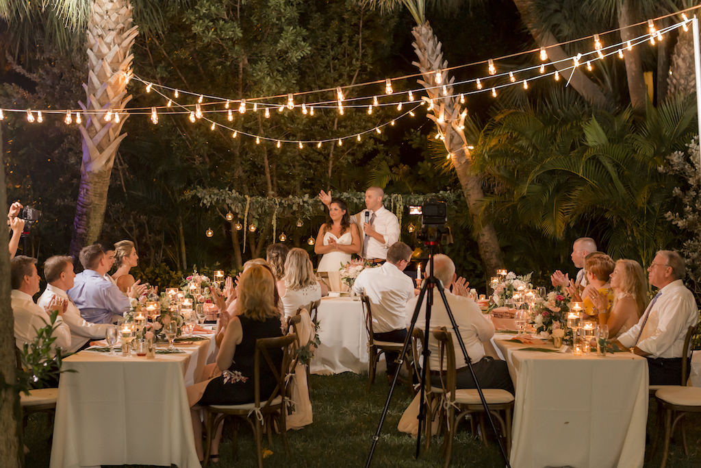 St. Pete Bride and Groom Giving Speech During Outdoor Garden Wedding Reception with String Lights