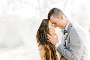 Romantic Tampa Bay Bride and Groom Wedding Portrait with Veil Flowing, Groom in Light Gray INDOCHINO Suit